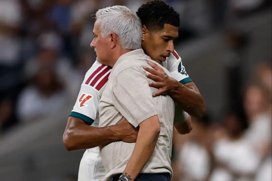 Football player Jude Bellingham hugging coach Jose Mourinho.