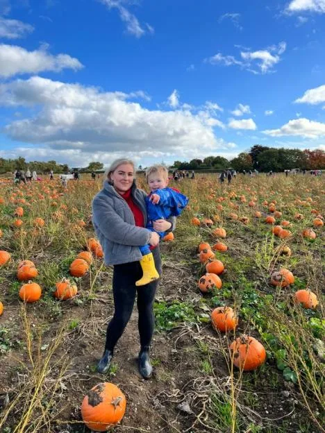 Jess Hulley-Jones holding her son Theodore in a pumpkin patch.