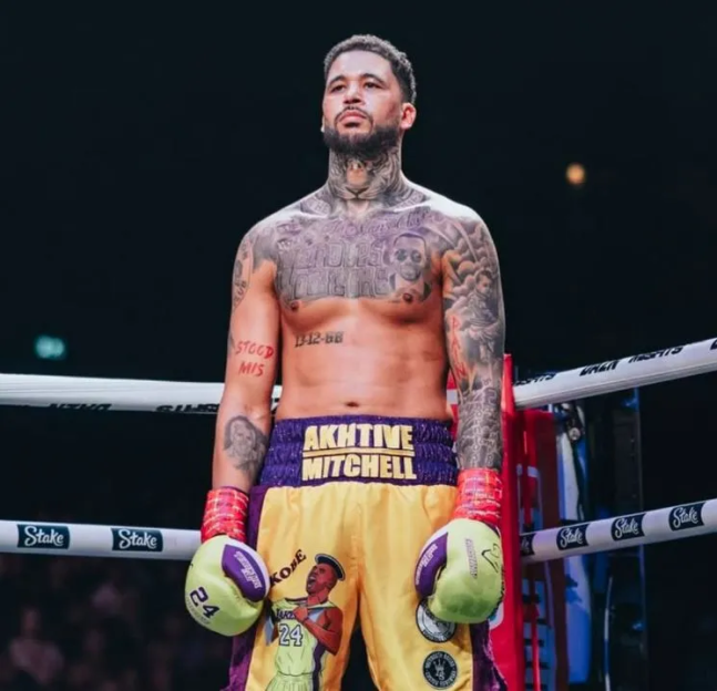 Professional boxer Akhvative Mitchell standing in a boxing ring, looking up.