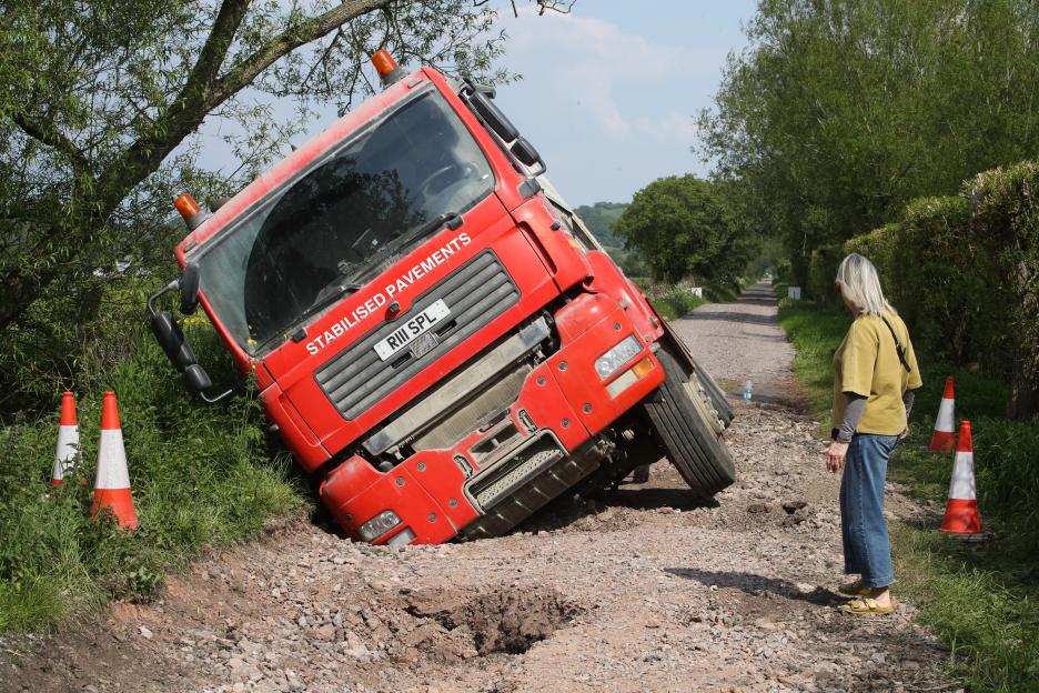 Lorry Trapped in Massive Sinkhole While Attempting Repairs – Workmen Forced to Walk Away!