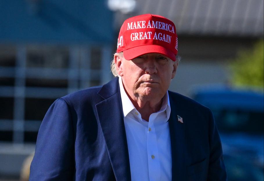 President Trump walking while wearing a "Make America Great Again" hat.