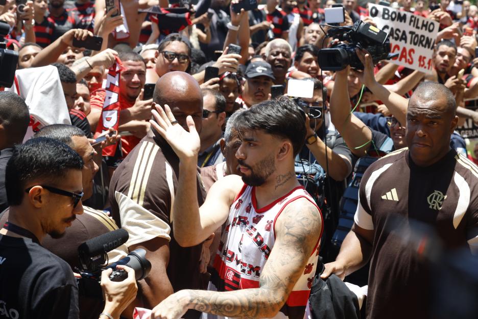 Lucas Paqueta waving to a crowd of Flamengo fans at Rio de Janeiro International Airport.