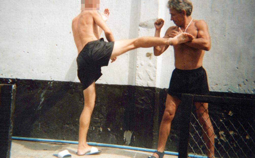 Jonathan Wheeler demonstrating a kick with another man during Muay Thai training in Thailand.