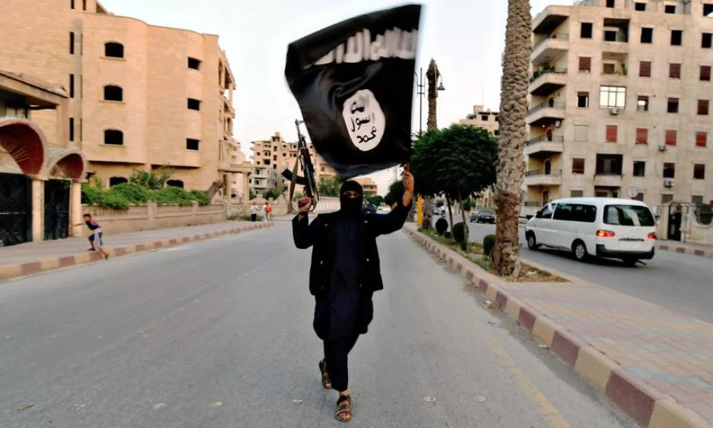 Islamic State of Iraq and the Levant fighter waves a Black flag during a military parade in Raqqa province in Syria June 29, 2014 shown in propaganda photos released by the militants.
