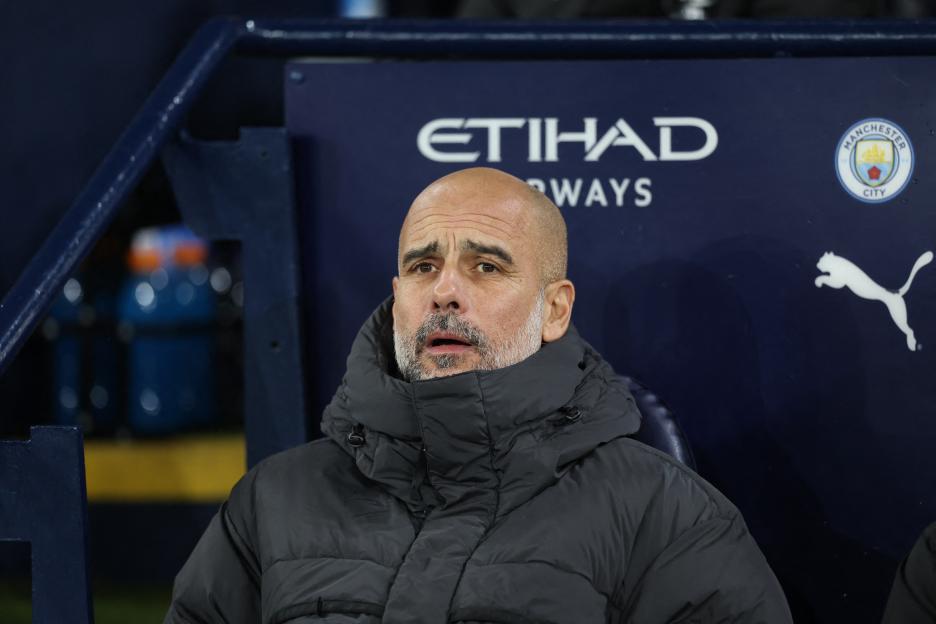 Manchester City manager Pep Guardiola seated at the Etihad Stadium.