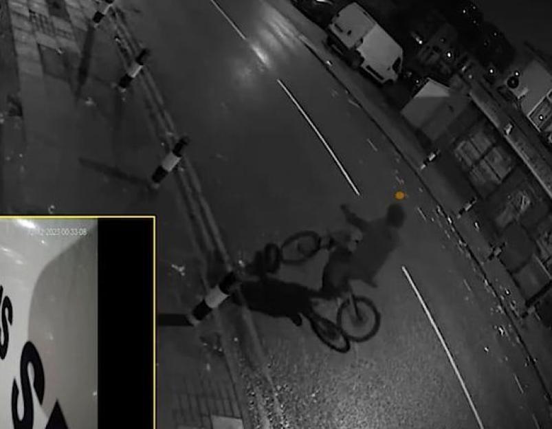 Security footage captures a man on a bicycle firing a gun at a car on a street at night.