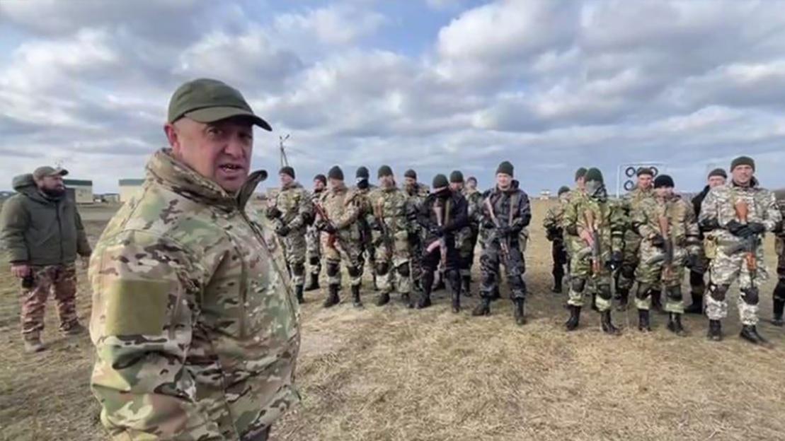 Leader of the Wagner Group, Yevgeny Prigozhin, speaking to a group of armed soldiers in camouflage.