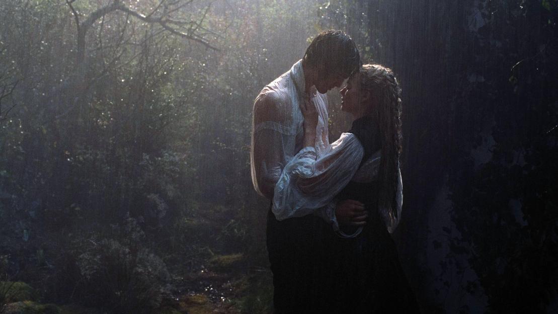 Film still of Jacob Elordi as Heathcliff and Margot Robbie as Catherine Earnshaw in Wuthering Heights (2026), embracing in the rain.