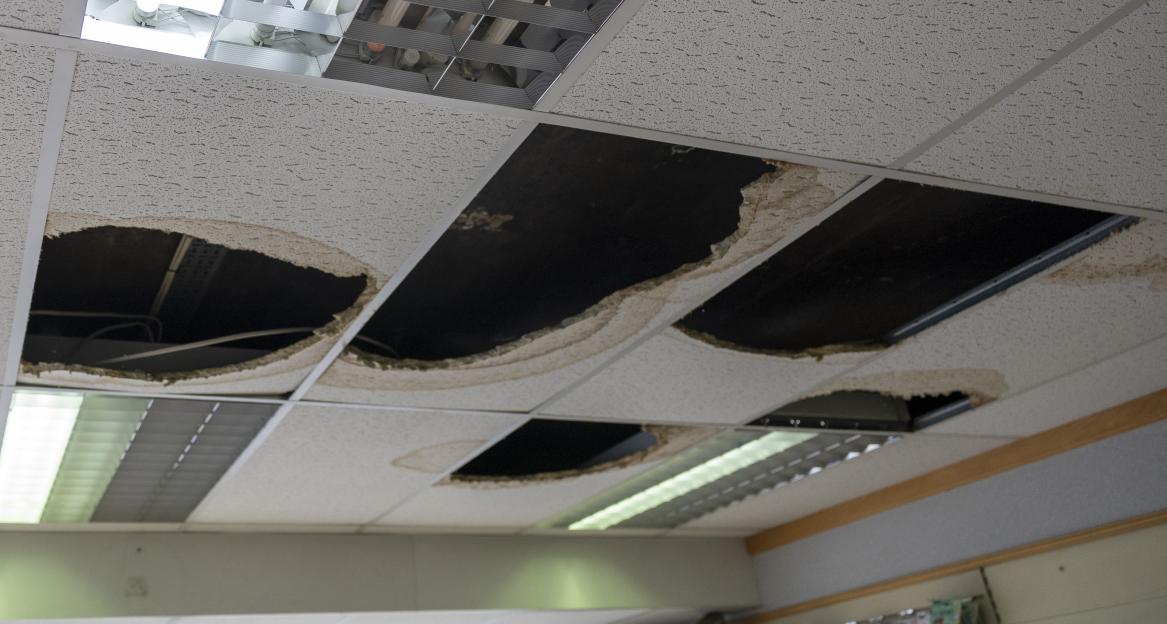 Damaged ceiling panels of a pharmacy from water leaks.