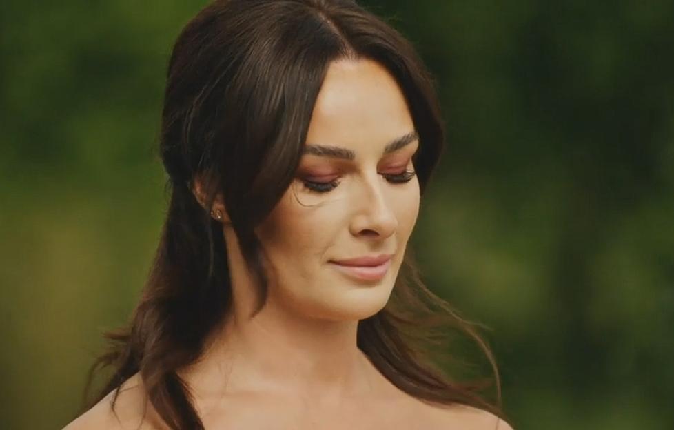A woman with long dark hair, pink eyeshadow, and a subtle smile.