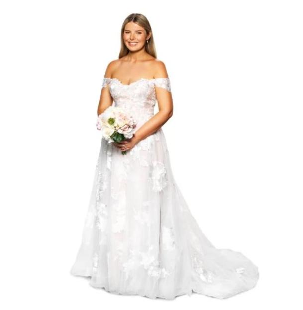 Olivia Frazer smiling in a wedding dress, holding a bouquet.