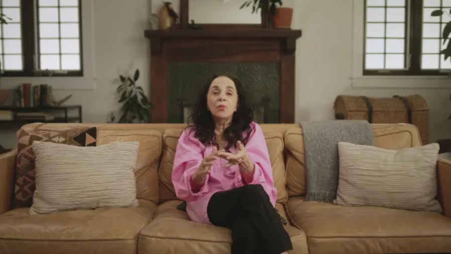 Journalist Laura Greenberg sitting on a couch.