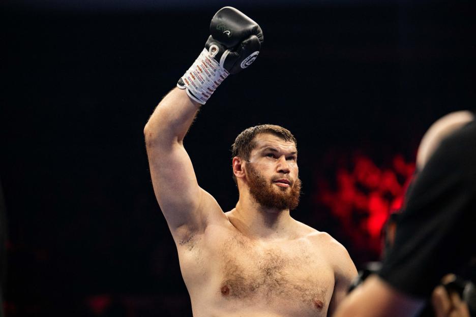 Boxer Adam Azim raises his gloved arm in victory.