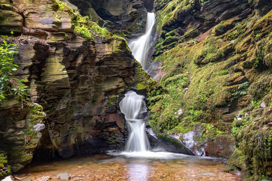 St Nectans Kieve waterfall cascading through a rock formation.