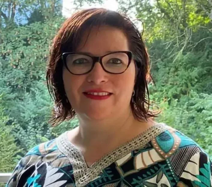 Dr Luz Maria De Regil wearing glasses and a patterned top against a backdrop of trees.