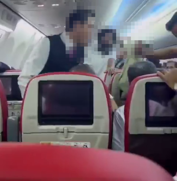 Flight attendants and passengers trying to restrain a passenger who allegedly attempted to open an emergency door.