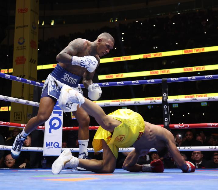 Conor Benn stands over a fallen Chris Eubank Jr. in the boxing ring.
