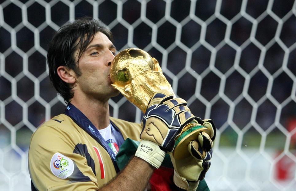 Italian goalkeeper Gianluigi Buffon kissing the World Cup trophy while wearing his goalkeeper gloves.