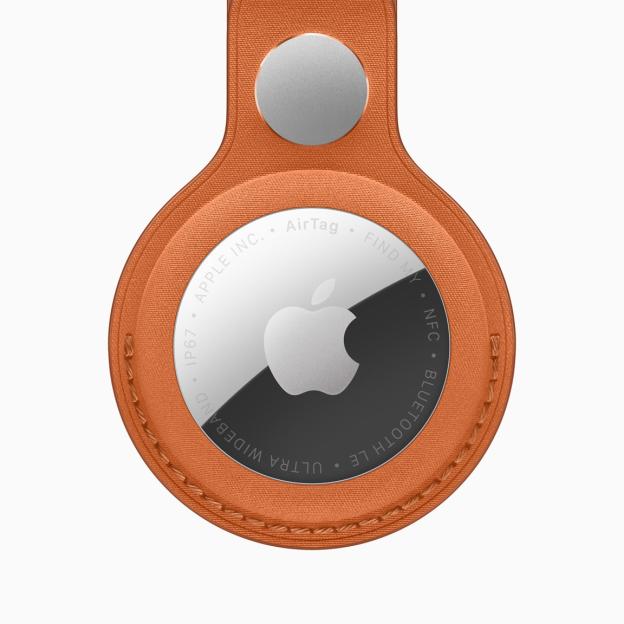 Apple AirTag in an orange leather case.