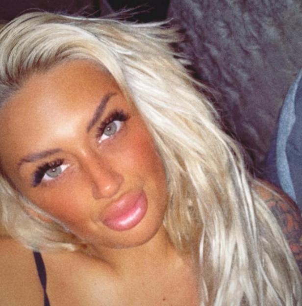 Headshot of Nicole Hutchinson, a blonde woman with full lips and heavy eye makeup.