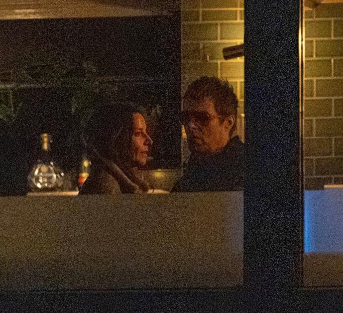 Liam Gallagher and Debbie Gwyther talking in a bar.
