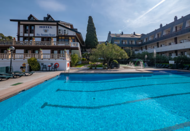 An outdoor swimming pool in front of the Sta. Susanna Resort hotel.