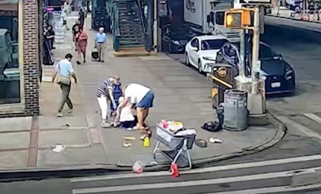 People assisting a person who collapsed on a city sidewalk.