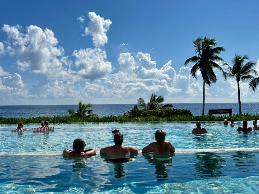 People in an infinity pool overlooking the ocean.