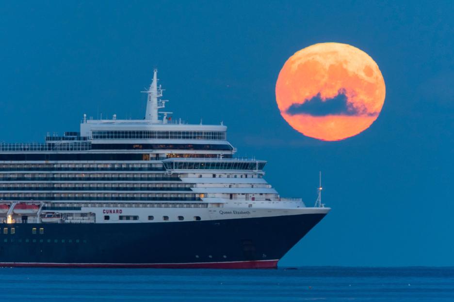 Weymouth, Dorset, UK. 1st Septembert 2020. UK Weather. The full Harvest Moon rises up from behind the Cunard cruise ship Queen Elizabeth which is at anchor off the coast of Weymouth in Dorset. Picture Credit: Graham Hunt/Alamy Live News