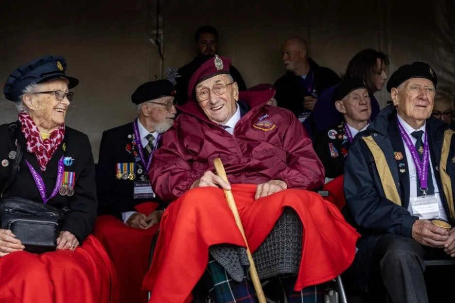 Geoffrey Roberts, 101, smiles while flanked by other WWII veterans at an Airborne commemoration for Operation Market Garden.