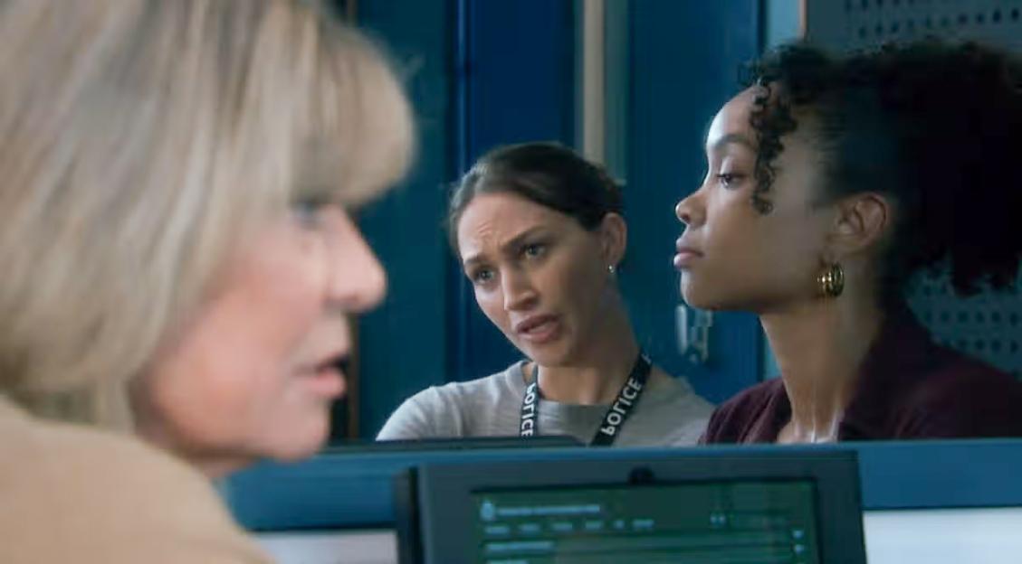 Two female police officers listening to a woman.