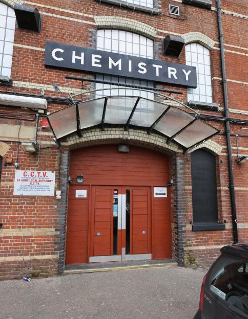 The exterior of a red brick building with a sign above the arched doorway that reads "CHEMISTRY".