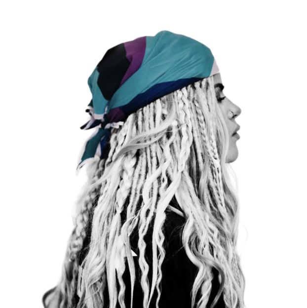 Profile of a pop artist with blonde dreadlocks and a colorful headscarf.