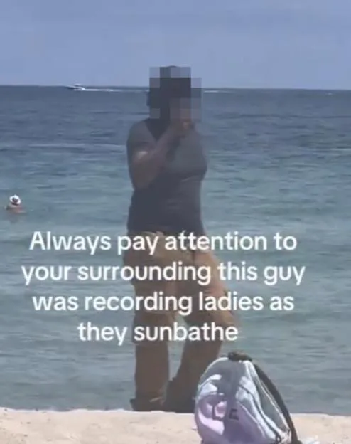 A man standing on a beach with the ocean behind him, with text overlaid that reads: "Always pay attention to your surrounding this guy was recording ladies as they sunbathe".