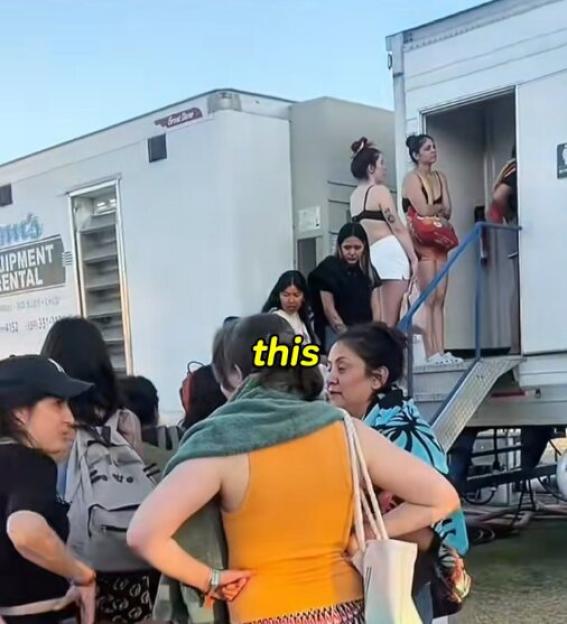 Festival-goers wait in line for portable bathrooms.