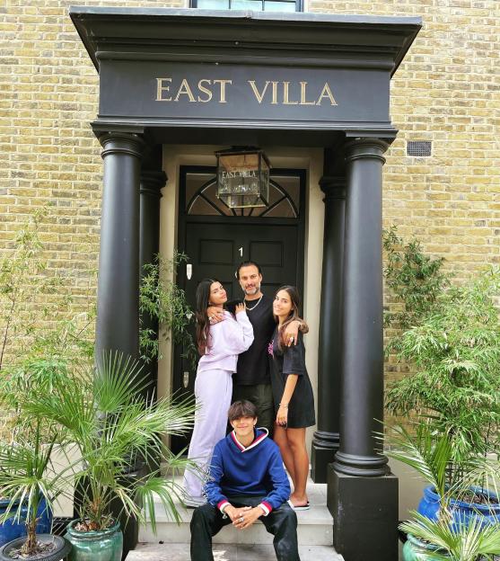 Made in Chelsea Issy with her dad Marc and two siblings stand in front of a doorway.