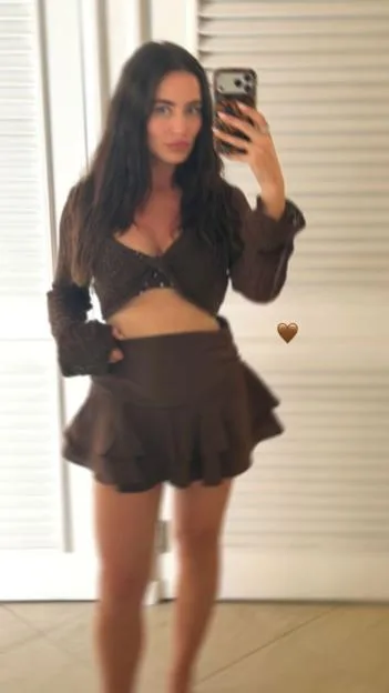 Fern Maguire takes a mirror selfie wearing a brown crop top and skirt.