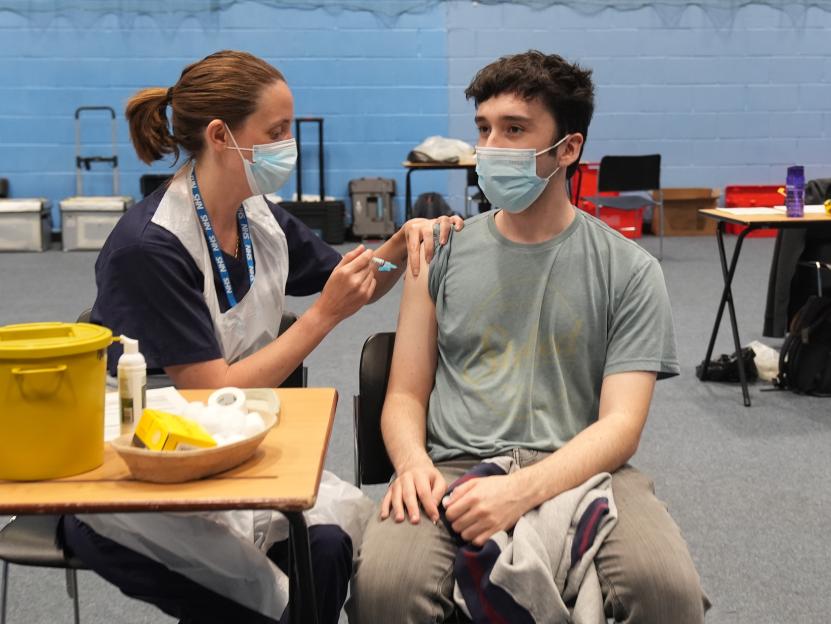 A nurse administers a meningitis B vaccine to postgraduate law student Oliver Contreras at the University of Kent campus.