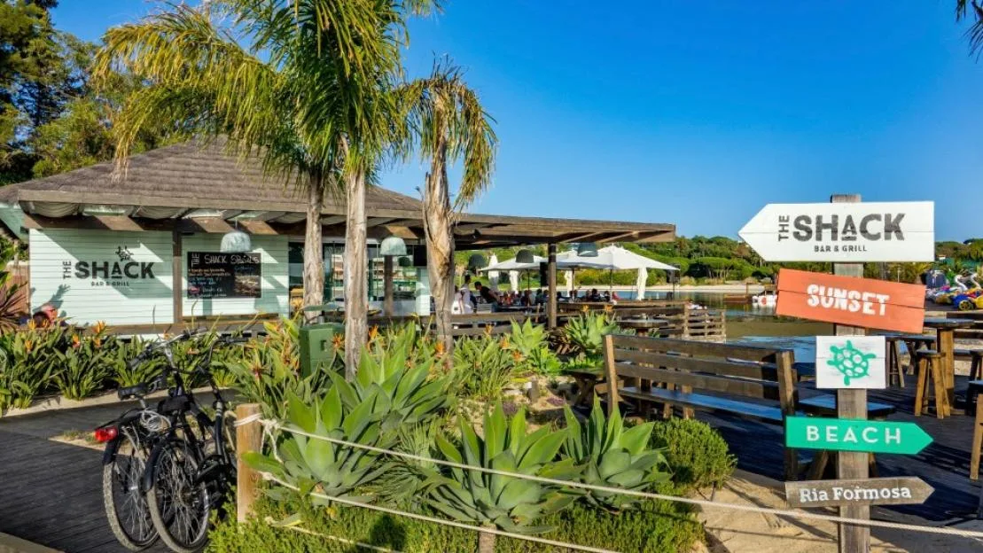 The Shack Bar & Grill at Quinta do Lago, with signs pointing to Sunset, Beach, and Ria Formosa.