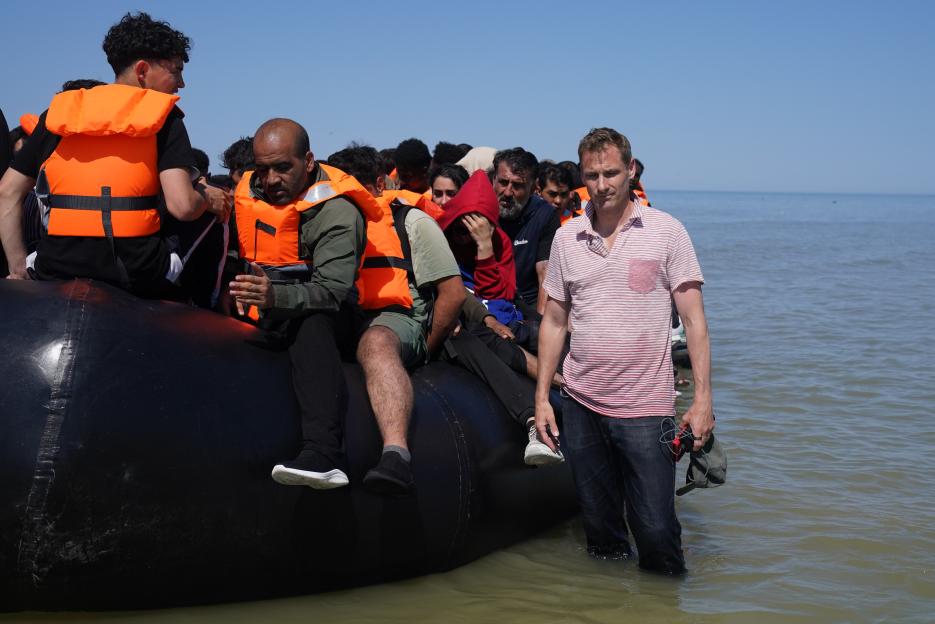 Shadow Home Secretary Chris Philp stands with migrants on a small boat off the coast of Hardelot, France, during an attempt to cross the English Channel.