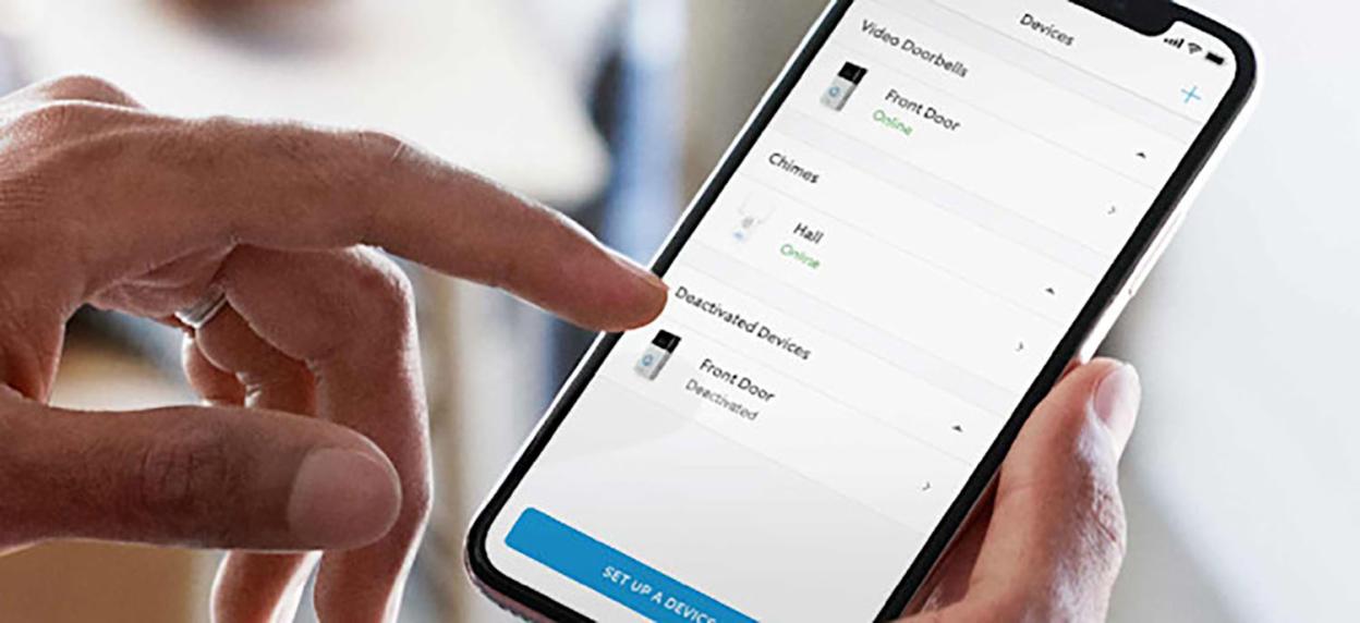 A person's hands holding a smartphone displaying the Ring app.
