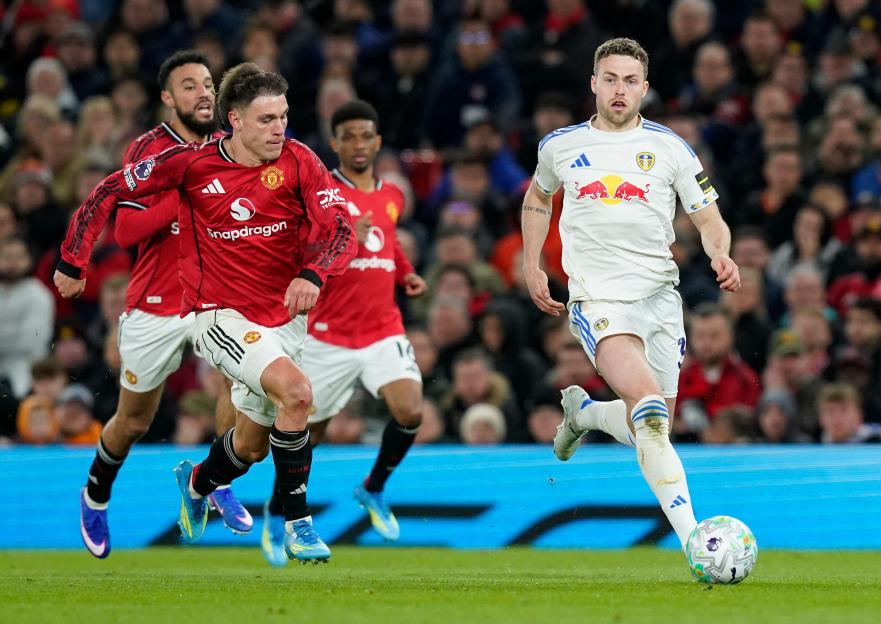 Manchester, UK. 13th Apr, 2026. Gabriel Gudmundsson of Leeds United with the ball under pressure from Manuel Ugarte of Manchester United during the Manchester United vs Leeds United Premier League match at Old Trafford, Manchester. Picture credit sho