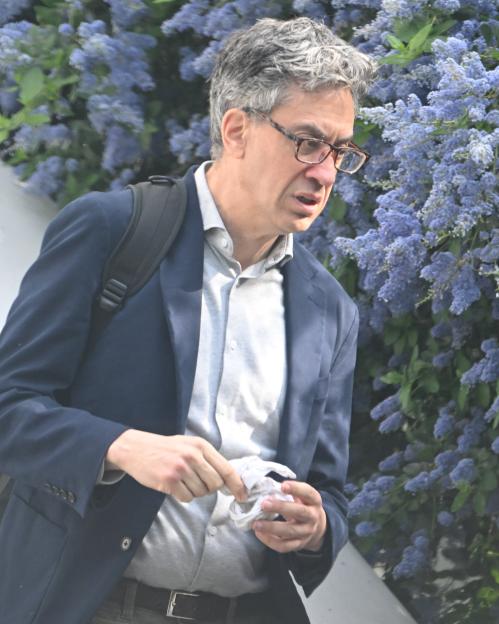 Ed Miliband holding a handkerchief outside his home.