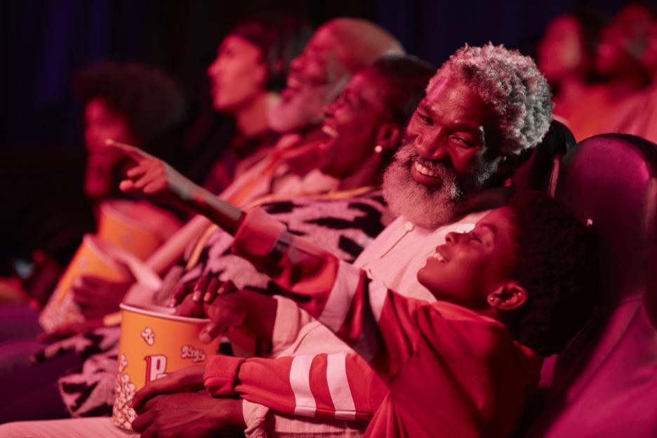 Happy father and daughter watching a show in a theater.