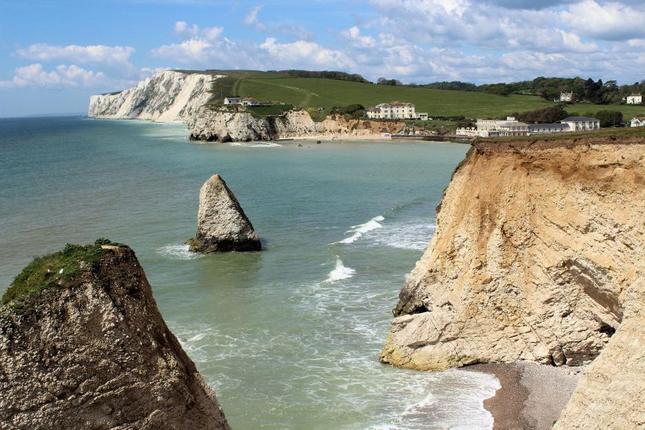 View of Freshwater Bay and Tennyson Down on the Isle of Wight, with a sandy beach and cliffs.