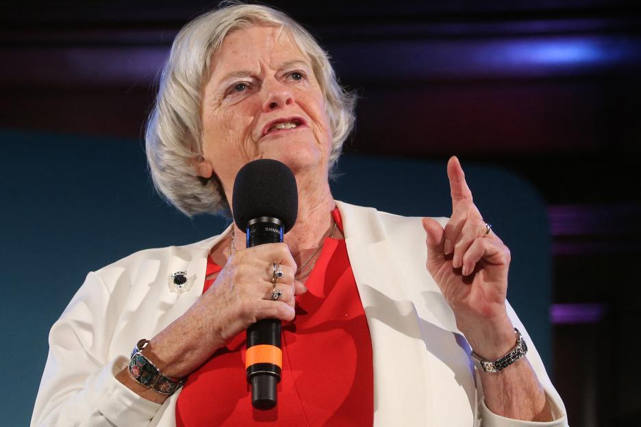 Ann Widdecombe speaking into a microphone with her left hand raised and index finger pointing.