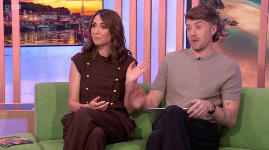 A woman in a brown dress and a man in a light brown shirt sitting on a green sofa.