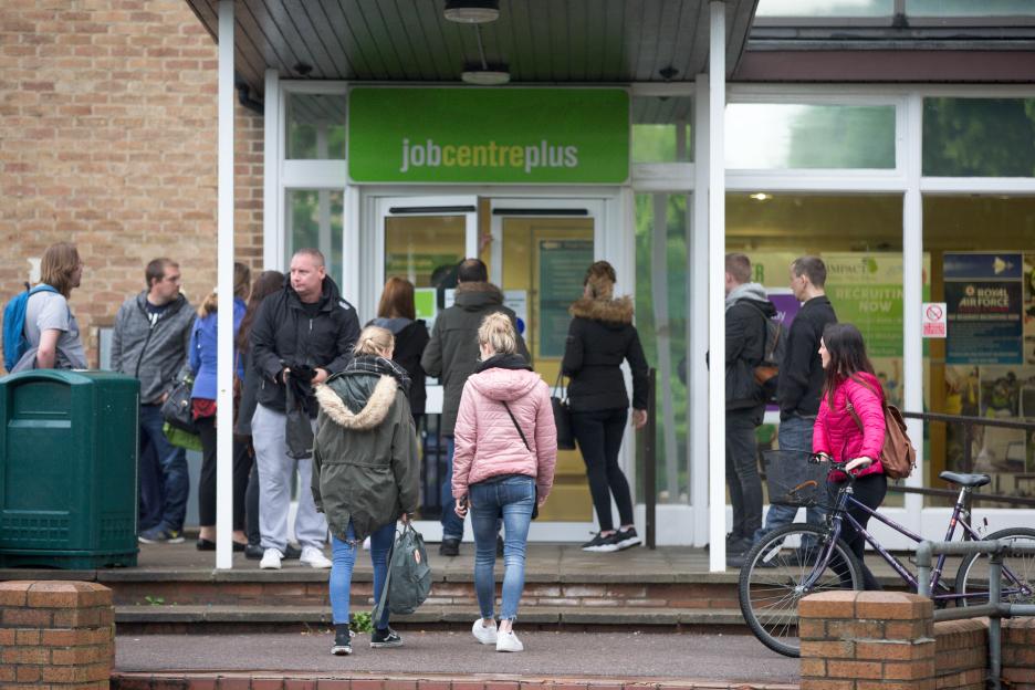 People entering and exiting a Job Centre Plus building.