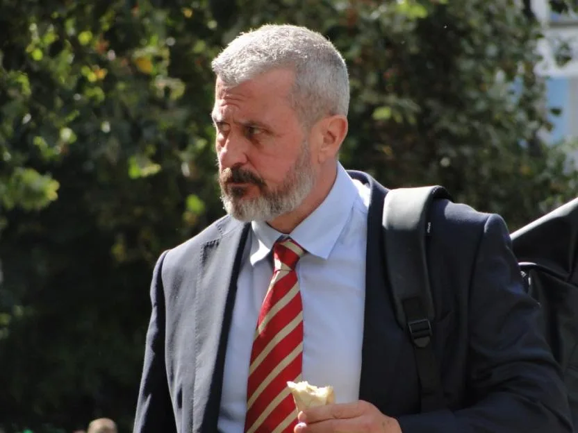 Darren Cooper wearing a suit and tie outdoors.