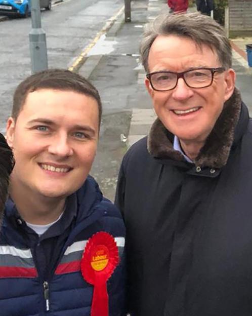 Five people, including Lord Mandelson, posing for a selfie outside.